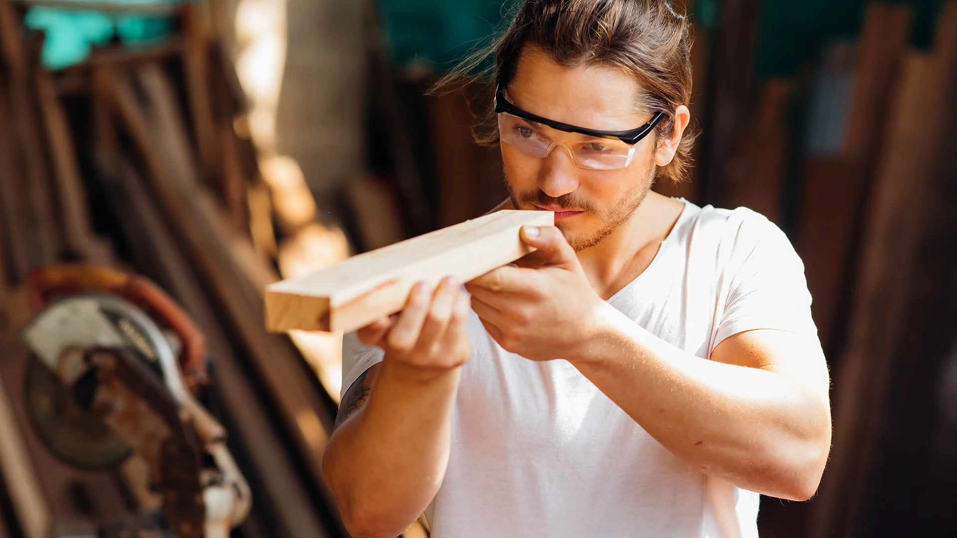 Man looking at wood at workshop